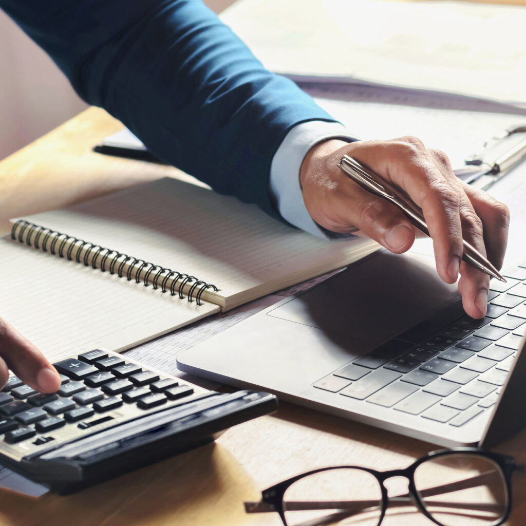 businessman working on desk with using calculator and computer i